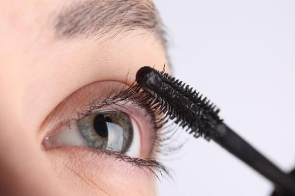 Девушка красит ресницы Касторовое масло для ресниц