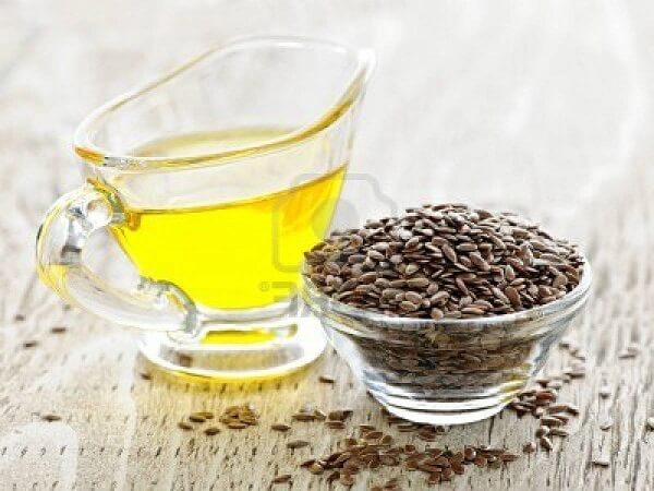 Масло льняное и семена льна в чашке Льняное масло - фото