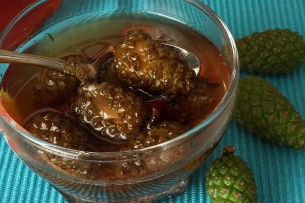 Готовое варенье из шишек в миске Варенье из сосновых шишек в чашке